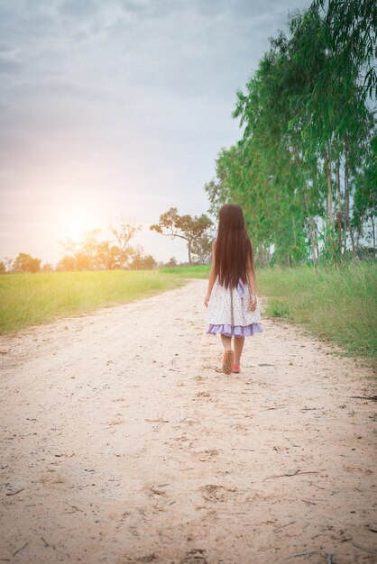 Petite fille avec robe cheveux longs portant marche loin de yo