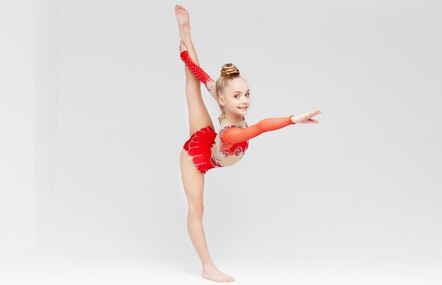 Jolie Petite Fille Faisant De La Gymnastique Avec Un Ballon Sur Fond Blanc