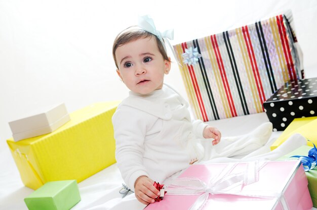 Petite fille avec un ruban bleu entouré de cadeaux