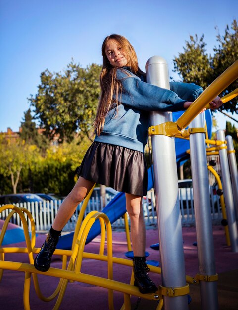 Petite fille s'amusant sur l'aire de jeux en plein air