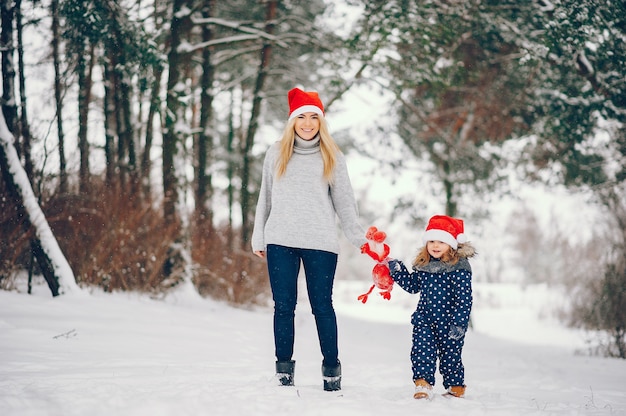 Petite fille avec sa mère jouant dans un parc d'hiver