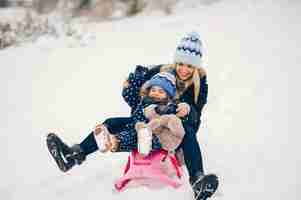 Photo gratuite petite fille avec sa mère jouant dans un parc d'hiver