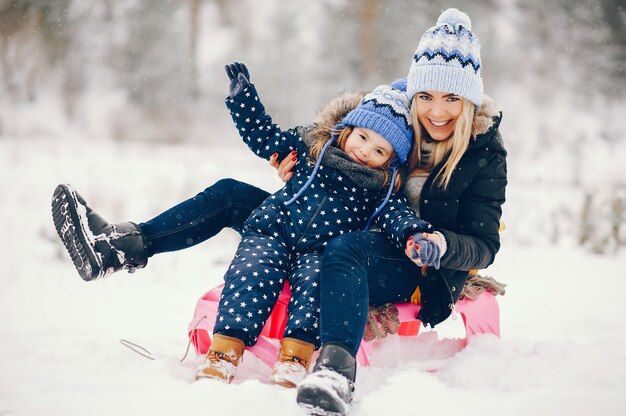 Petite fille avec sa mère jouant dans un parc d'hiver