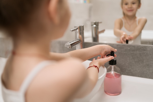 Petite fille se laver les mains avec du savon