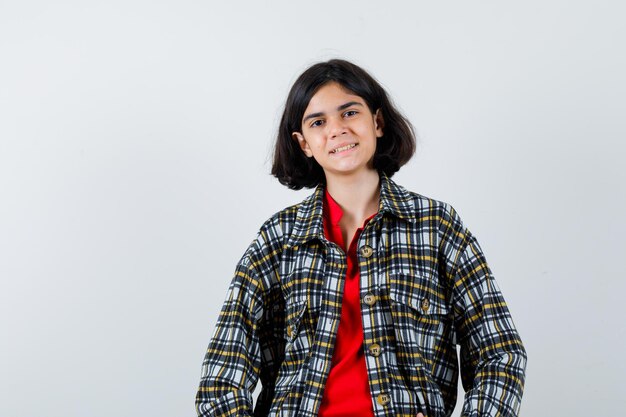 Petite fille souriante en chemise, veste et l'air heureux, vue de face.