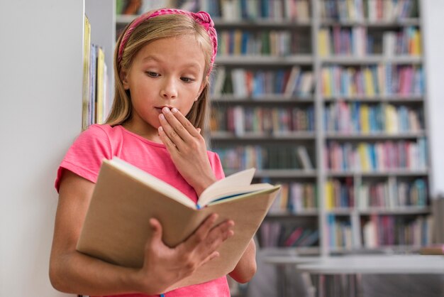 Petite fille à la surprise après avoir lu quelque chose d'intrigant