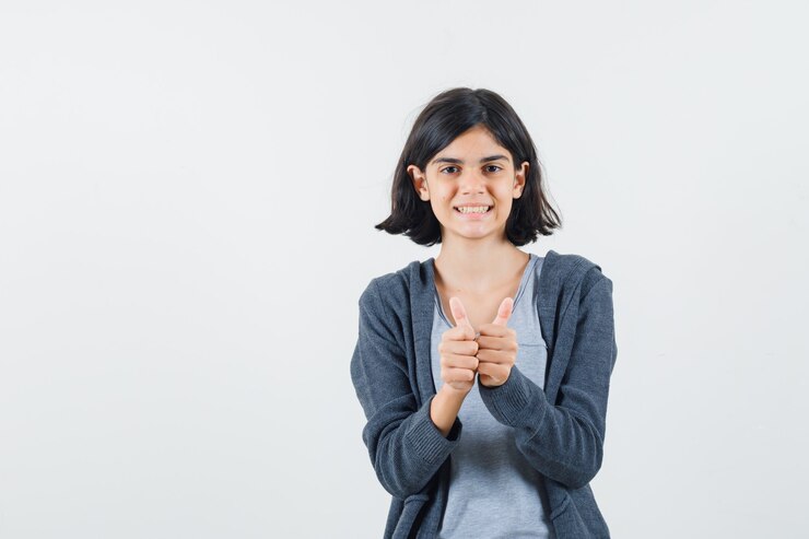 Photo gratuit petite fille en t-shirt, veste montrant deux pouces vers le haut et à la joie