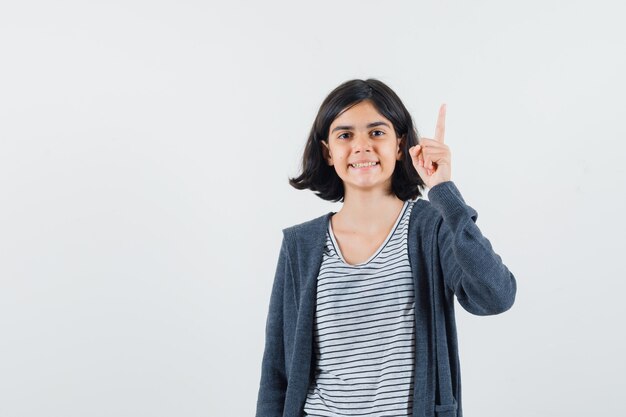 Petite fille en t-shirt, veste pointant vers le haut et à la confiance