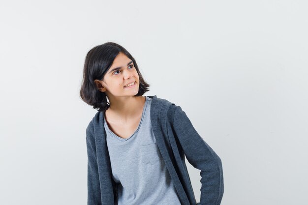 Petite fille en t-shirt, veste à la recherche et à la rêverie