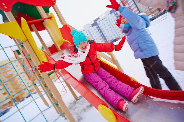 Petite fille sur le terrain de jeu en hiver