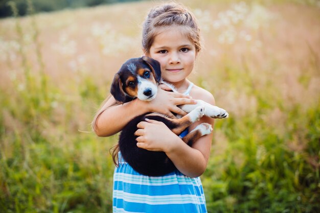 Petite fille tient un chiot sur ses bras