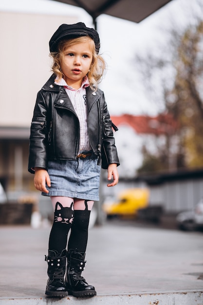 Petite fille vêtue d'une tenue à la mode dans le parc