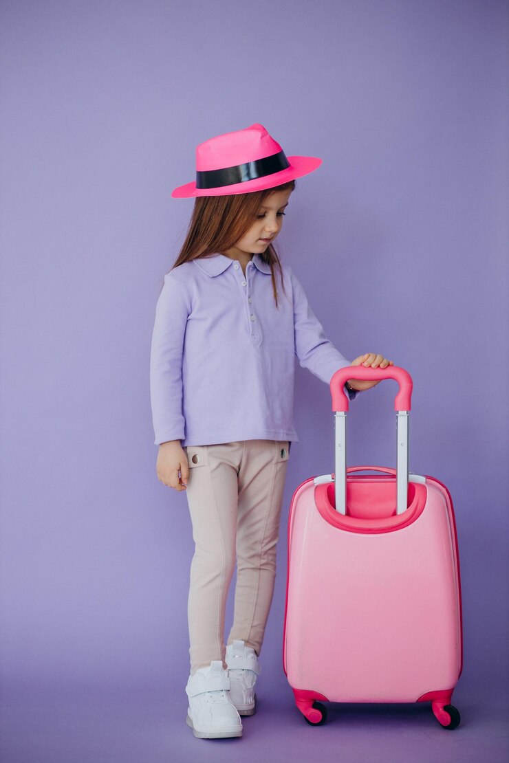 Photo gratuit petite fille voyageant avec une valise de voyage