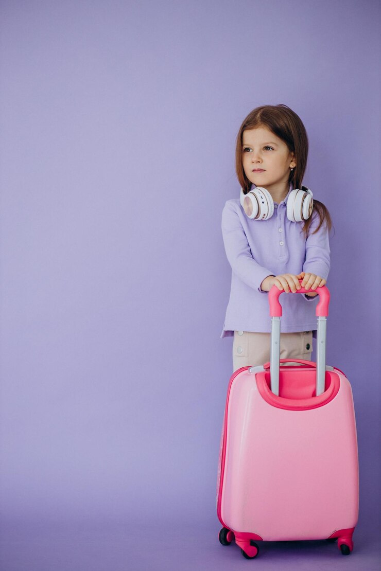 Photo gratuit petite fille voyageant avec une valise de voyage