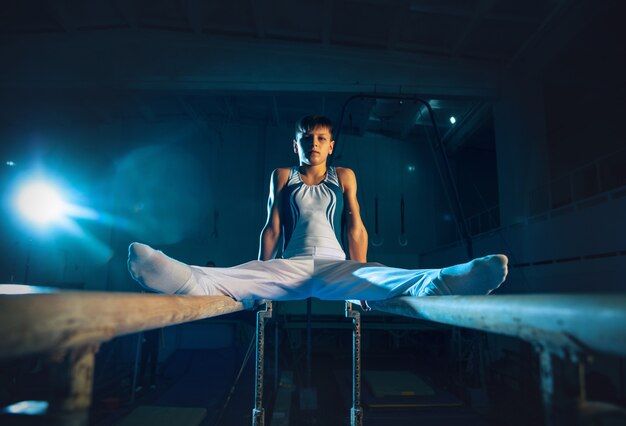 Petite formation de gymnaste masculin dans une salle de sport, flexible et active