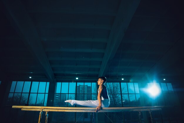 Petite formation de gymnaste masculin dans une salle de sport, flexible et active