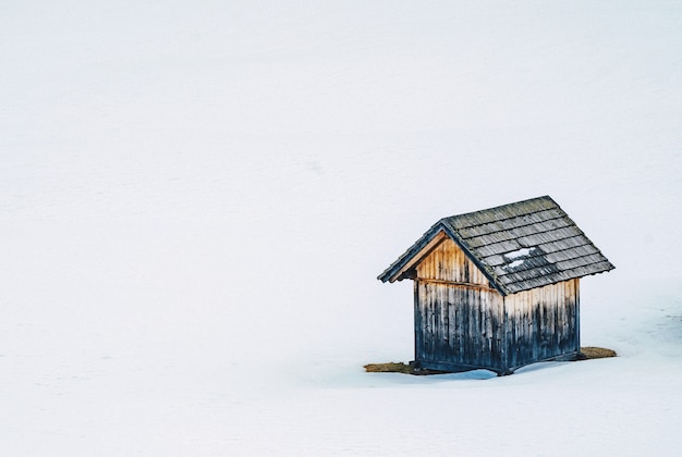 Petite grange en bois dans un champ enneigé