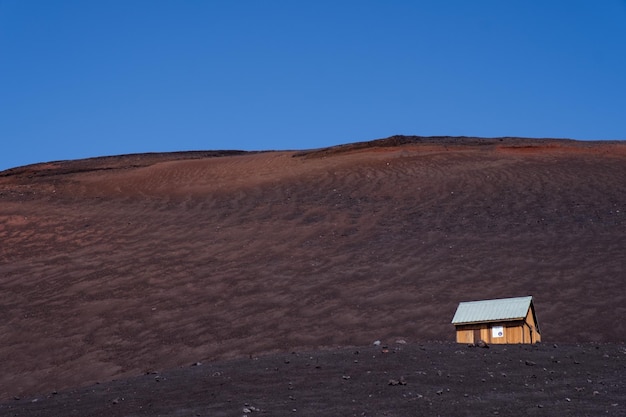 Photo gratuite petite maison isolée sur un grand terrain sous le ciel bleu clair
