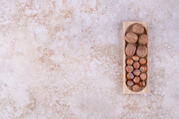 Une petite planche de bois pleine de noix saines.