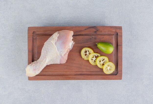 Une petite portion de cuisse de poulet et de tranches de citron, sur la surface bleue