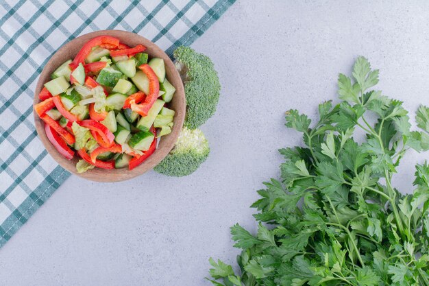 Petite portion de salade de poivre et de concombre à côté d'un petit paquet de feuilles de persil sur fond de marbre. photo de haute qualité