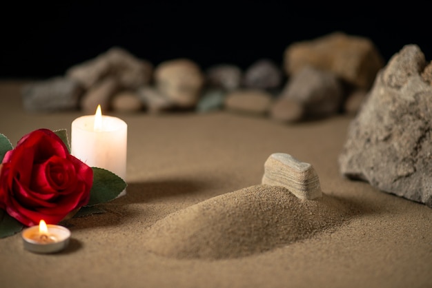 Petite tombe avec bougie et pierres sur lune de guerre funéraire sable