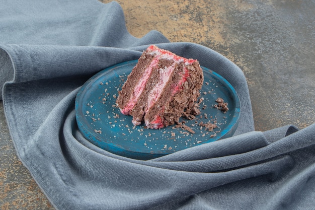 Petite tranche de gâteau sur un plateau bleu sur un morceau de tissu