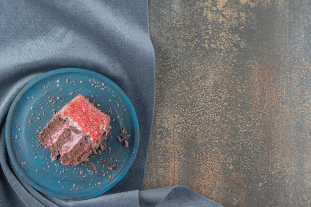 Petite tranche de gâteau sur un plateau bleu sur un morceau de tissu