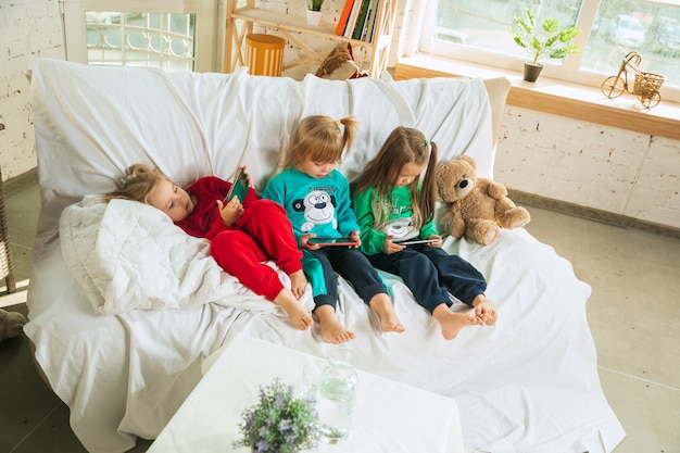 Petites filles en pyjama doux et chaud jouant à la maison