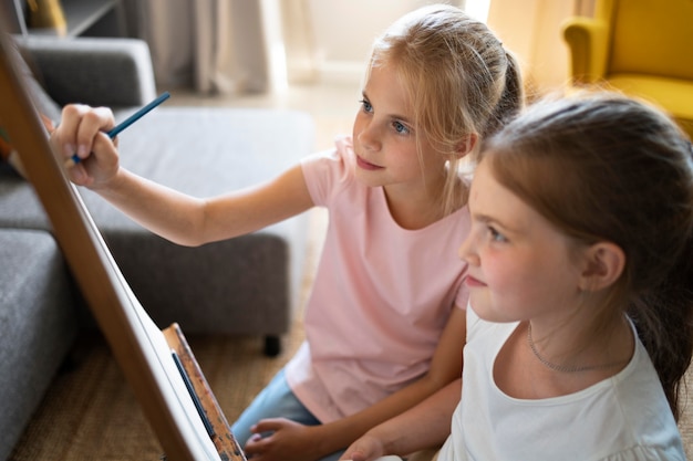 Petites filles s'assemblant à la maison sur le chevalet