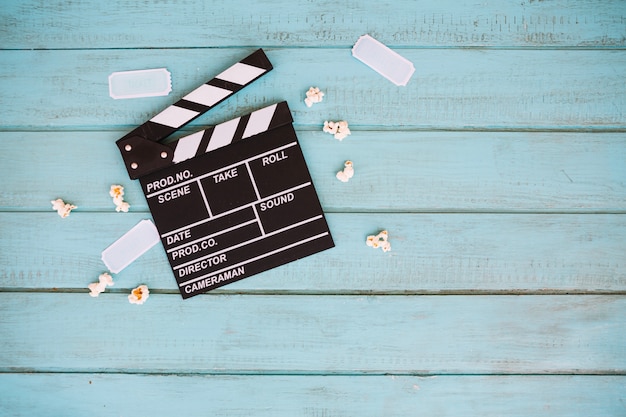 Photo gratuite petits billets et maïs soufflé près de clapperboard