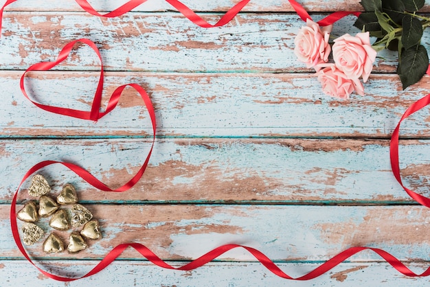 Petits coeurs avec des roses roses sur la table