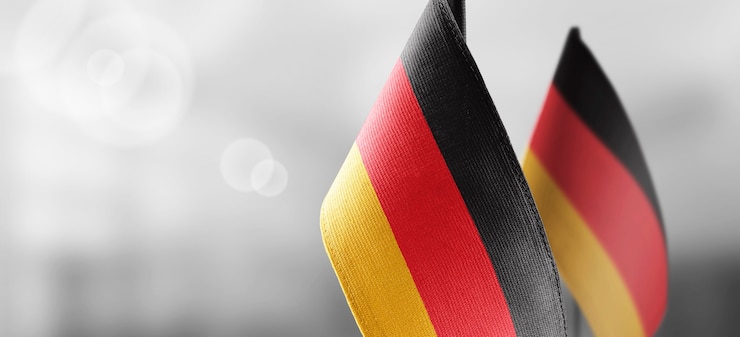 Photo gratuit petits drapeaux nationaux de l'allemagne sur un mur flou clair