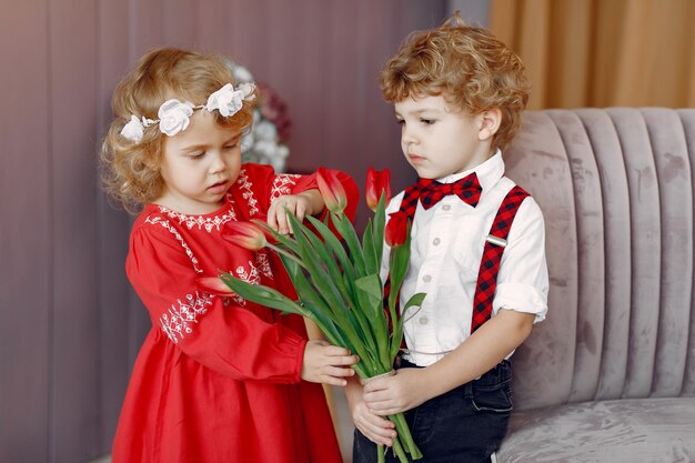 Petits enfants élégants avec bouquet de tulipe