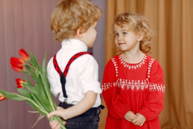 Petits enfants élégants avec bouquet de tulipe