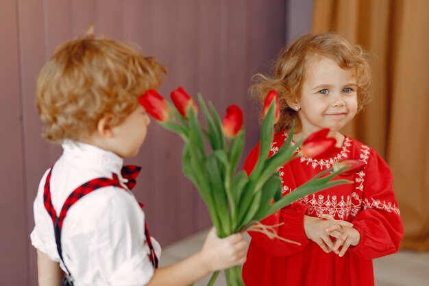 Petits enfants élégants avec bouquet de tulipe