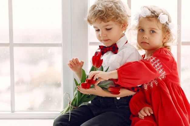 Petits enfants élégants avec bouquet de tulipe