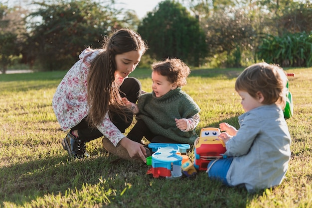 Petits enfants jouant leur soeur aînée sur le sol