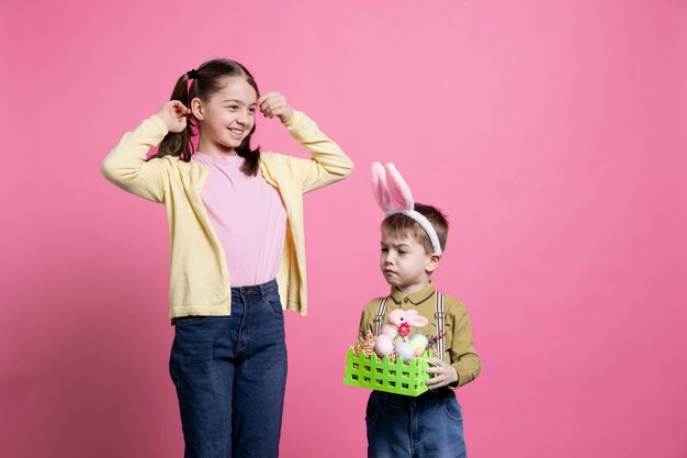 Petits enfants posant avec des décorations artisanales festives pour la célébration de Pâques