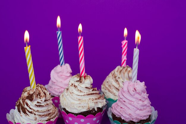 Petits gâteaux d&#39;anniversaire avec des bougies allumées
