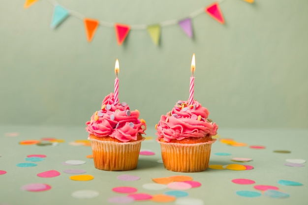 Petits gâteaux d&#39;anniversaire roses avec guirlande