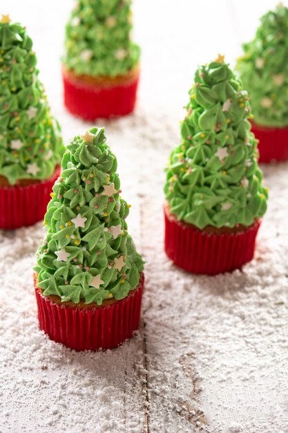 Petits gâteaux d'arbre de Noël sur la table en bois de neige