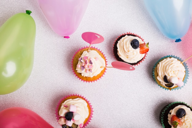 Petits gâteaux avec des ballons à air sur table lumineuse