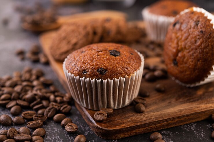 Photo gratuit petits gâteaux à la banane placés sur une assiette en bois avec des grains de café.