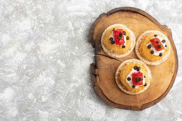 Petits gâteaux délicieux aux fruits sur un bureau en bois brun