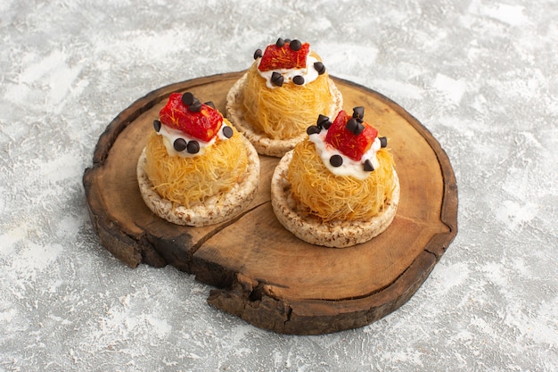 Petits gâteaux délicieux aux fruits sur un bureau en bois brun