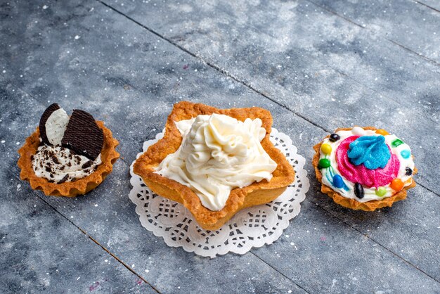 Petits gâteaux délicieux à la crème sur un gâteau sucré léger et bonbon