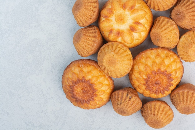 Petits gâteaux délicieux sucrés sur fond blanc