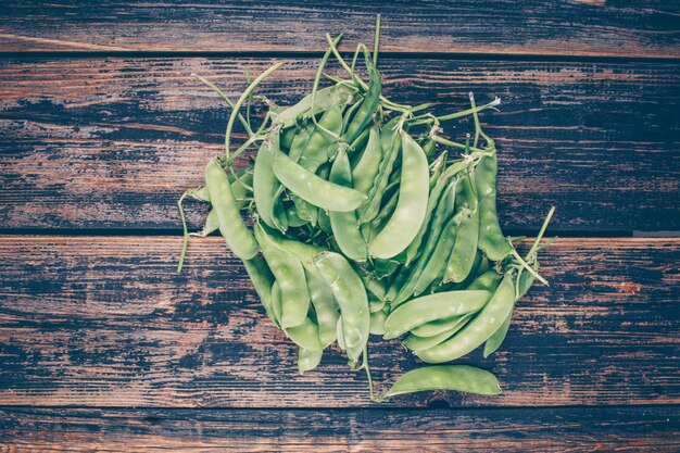 Petits et gros pois sur table en bois