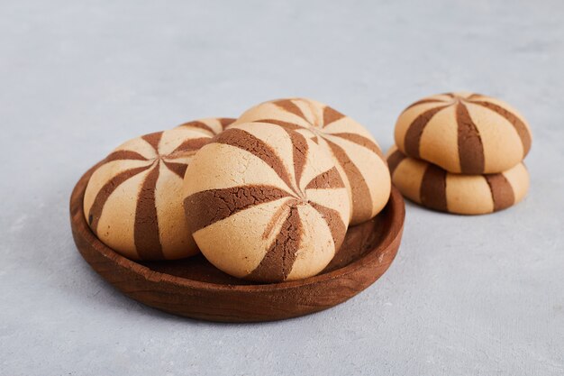 Petits pains biscuits au cacao et à la vanille dans un plateau en bois.